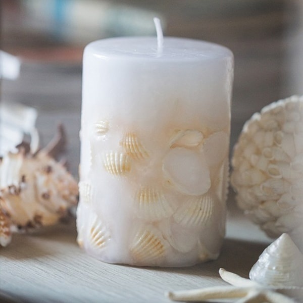 Give plain pillar candles a beachy look with sand and seashells